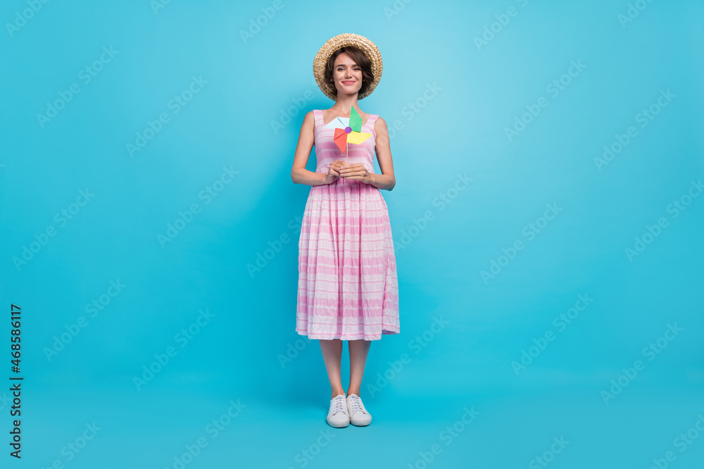 Full size photo of pretty millennial lady hold toy wear hat long sarafan isolated on blue background Full size photo of pretty millennial lady hold toy wear hat long sarafan isolated on blue background