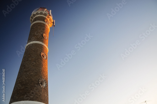 The José Ignacio lighthouse is illuminated by the golden light of the sun during sunset, Maldonado, Uruguay photo