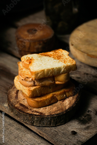 a pile of toasted white bread on the wooden paddle. a shot of the western breakfast suitable for advertisement or presentation.