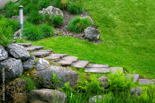 Принти на полотні stone staircase with steps made of wild natural stone on slope of hill park landscape with rock, ground garden lantern among green plants in summer environment for eco travel, nobody
