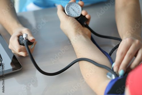 Doctor measuring patient blood pressure on arm using tonometer closeup