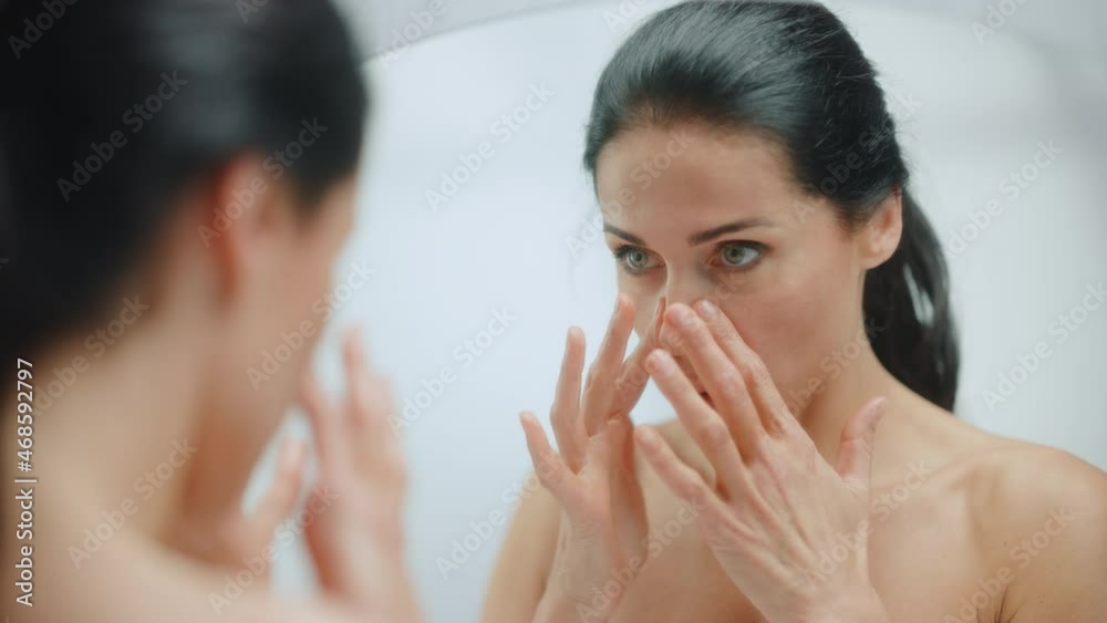 Caucasian Woman Looking in Mirror, Touching Beautiful Face, Soft Skin. Elderly Lady with Lush Black Hair. Female Beauty, Dignity, Grace. Sensual Wellness and Organic Skincare Products. Portrait Shot Caucasian Woman Looking in Mirror, Touching Beautiful Face, Soft Skin. Elderly Lady with Lush Black Hair. Female Beauty, Dignity, Grace. Sensual Wellness and Organic Skincare Products. Portrait Shot