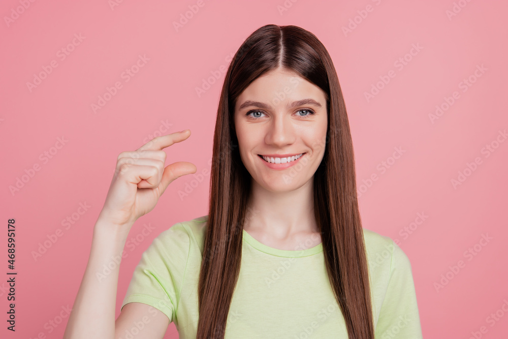Photo of young cheerful woman happy smile show fingers little small tiny size measure isolated over pink color background Photo of young cheerful woman happy smile show fingers little small tiny size measure isolated over pink color background