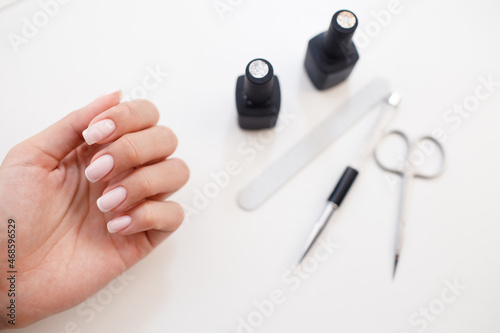 Manicure or pedicure supplies tools and hand on table.