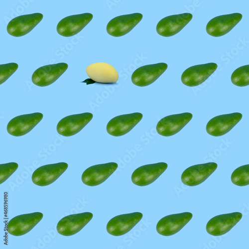 Seamless pattern made up of green avocados and one yellow mango