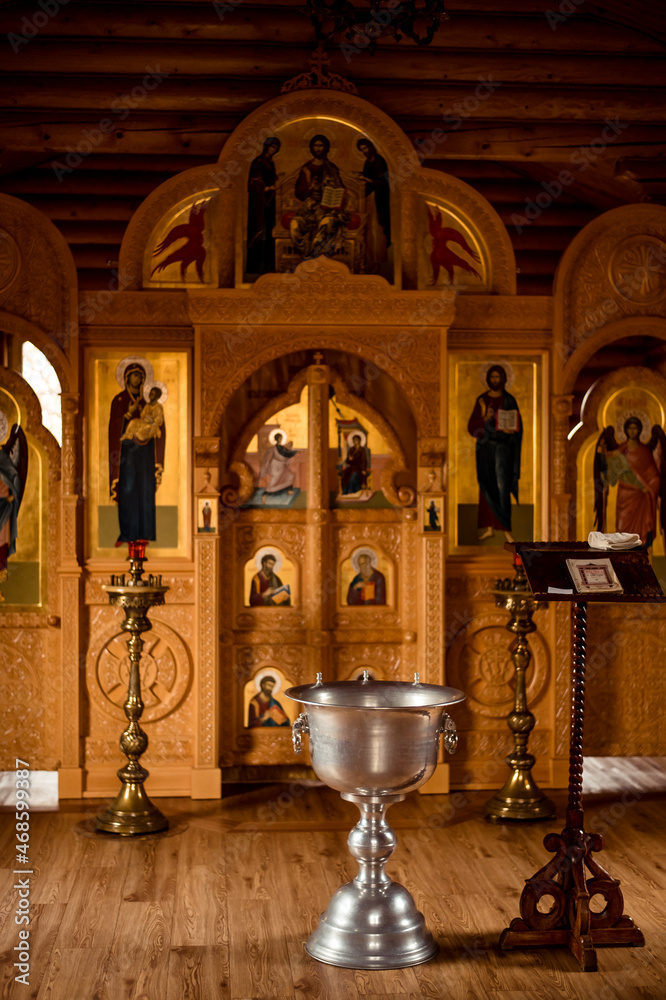 Fototapeta premium Holy water font for the baptism of children. The rite of initiation into the faith in the Christian temple. Church services - Liturgy of the baptism of children. Christian religious ceremony.