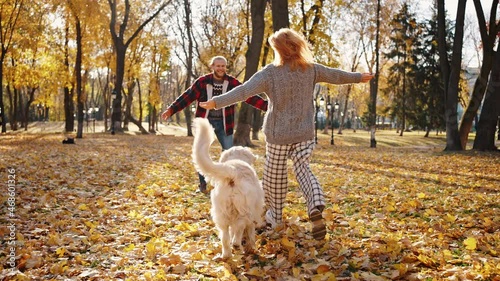 Wallpaper Mural Autumn date. Excited young woman running towards to her lovely boyfriend, meeting with dog in autumn park, follow shot Torontodigital.ca