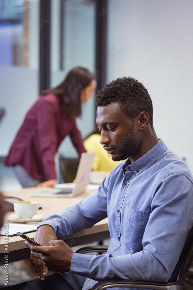 African american disabled businessman using smartphone and sitting in wheelchair in modern office African american disabled businessman using smartphone and sitting in wheelchair in modern office