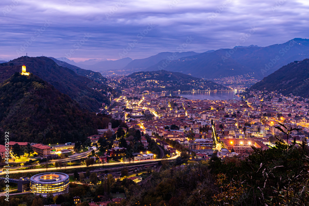  The city of Como, and the lake, photographed after sunset, with the mountains of Brunate, Castel Baradello, and the mountains overlooking the lake.
