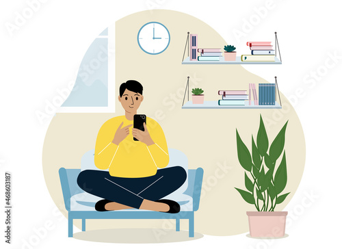 A man at home sits on an armchair with a mobile phone. Remote work or communication over the Internet.