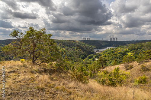 Forested landscape with dam and nuclear power plant on horizon