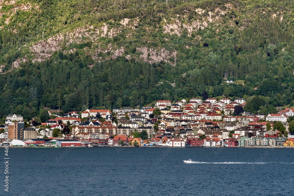 A panorama of Bergen in Norway from the seaside with a speedboat in the foreground