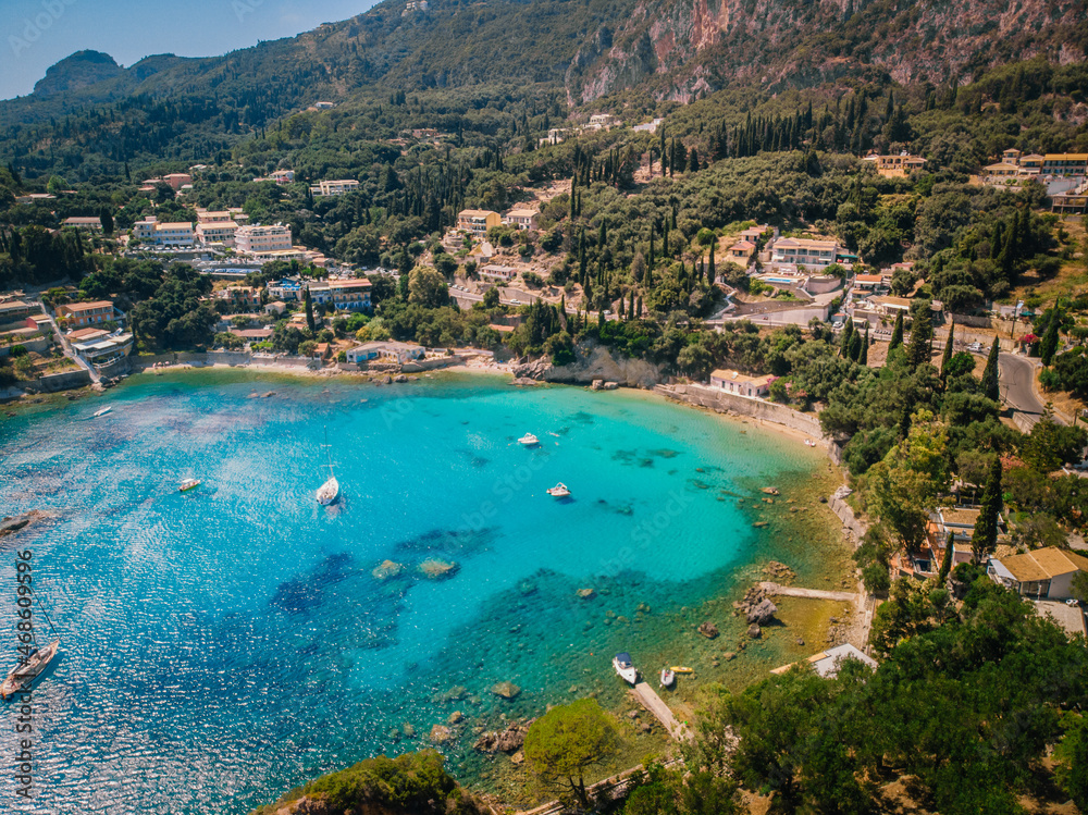 Aerial view of Paleokastritsa bay on a sunny day. Bay with beautiful turquoise water and boats.