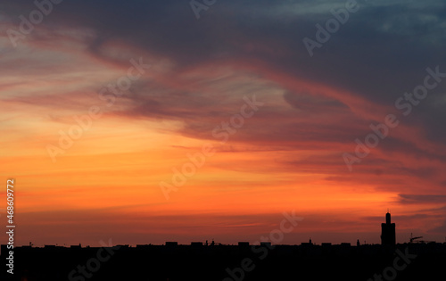 gorgeous sunset over a panoramic background city whit silhouettes of buildings