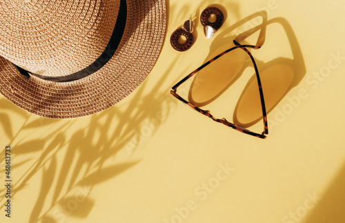 A fashionable composition with women's accessories and a floral shadow on a bright colorful yellow background.Concept of travel or vacation top view.Summer background. copy space.flat lay