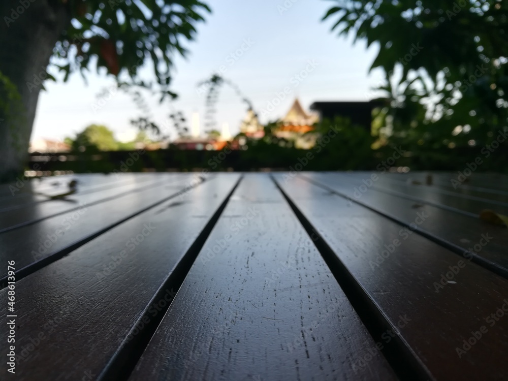 Wood floor with blurred trees of nature and sky background.