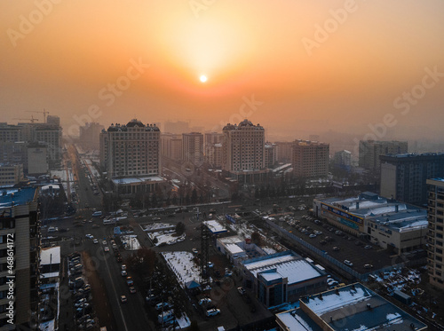 Sun shining through smog over southern Bishkek, Kyrgyzstan photo
