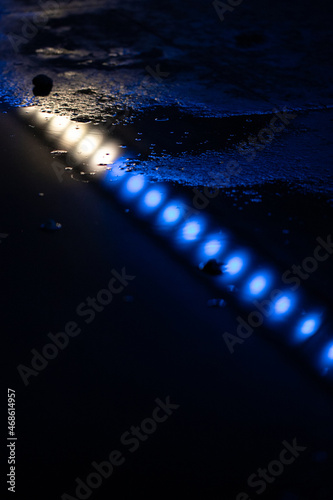 Neon lights reflected in water at night 