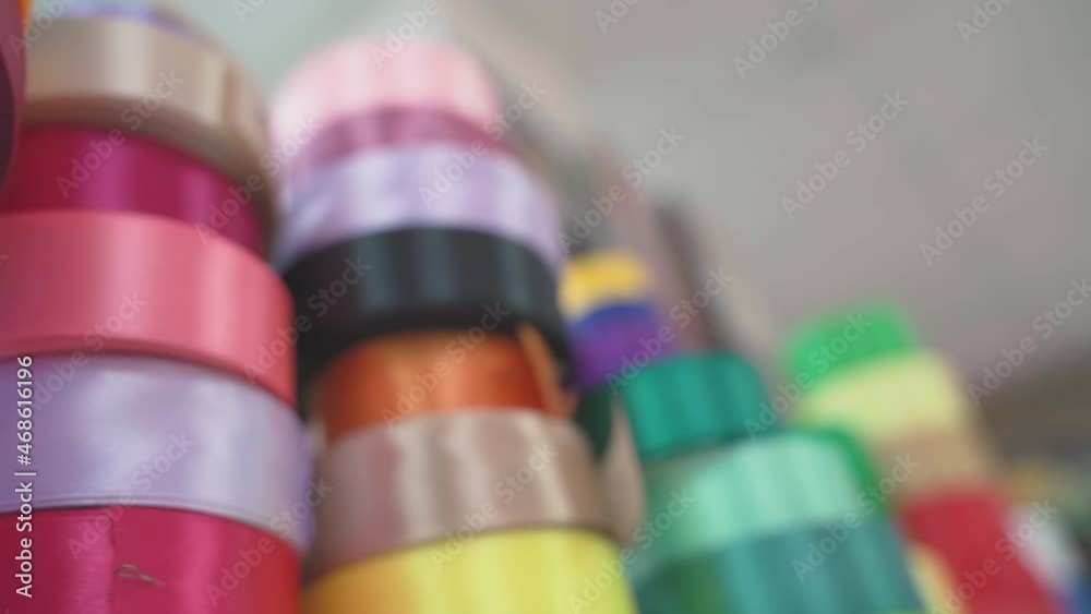 Background soft focus multi-colored braid, ribbons in fabric store. selects accessories, lace, fabrics, matching threads for tailor. working in atelier, handicraft, needlework Background soft focus multi-colored braid, ribbons in fabric store. selects accessories, lace, fabrics, matching threads for tailor. working in atelier, handicraft, needlework