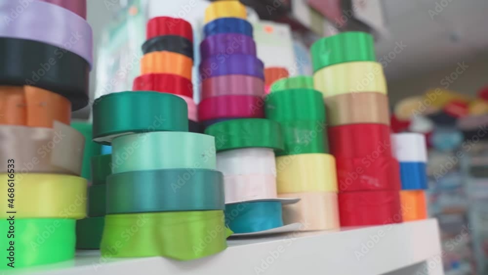 Background soft focus multi-colored braid, ribbons in fabric store. selects accessories, lace, fabrics, matching threads for tailor. working in atelier, handicraft, needlework Background soft focus multi-colored braid, ribbons in fabric store. selects accessories, lace, fabrics, matching threads for tailor. working in atelier, handicraft, needlework