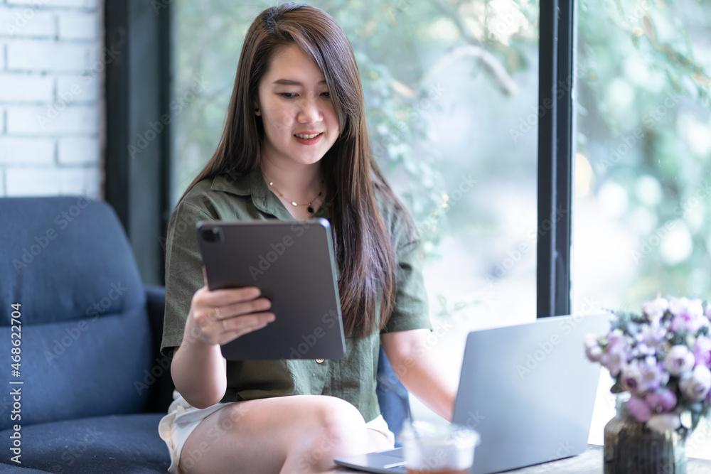 Happy of asian freelance people business female casual working with laptop computer and using tablet with coffee cup and smartphone in coffee shop like the background,communication concept