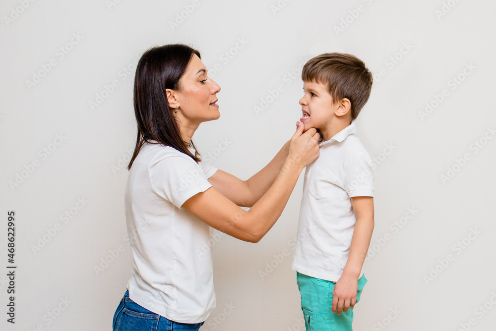 Attractive woman speech therapist teaches child to pronounce sounds and words correctly in office Attractive woman speech therapist teaches child to pronounce sounds and words correctly in office