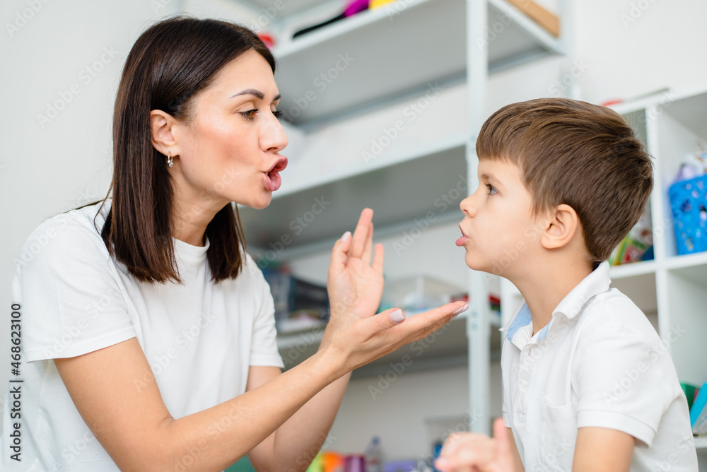 Cute woman speech therapist teaches child to pronounce words sounds and letters correctly in office Cute woman speech therapist teaches child to pronounce words sounds and letters correctly in office