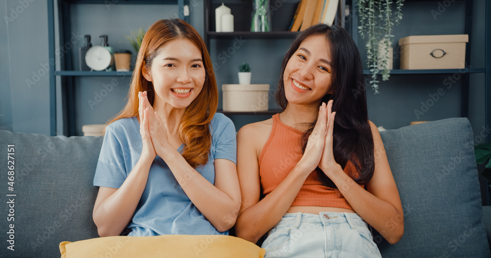 Teenager couple Asian women feeling happy smiling and looking to camera while relax in living room at home. Cheerful Roommate ladies video call with friend and family, Lifestyle woman at home concept. Teenager couple Asian women feeling happy smiling and looking to camera while relax in living room at home. Cheerful Roommate ladies video call with friend and family, Lifestyle woman at home concept.