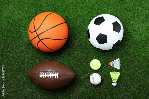 Set of different sport balls and shuttlecocks on green grass  flat lay