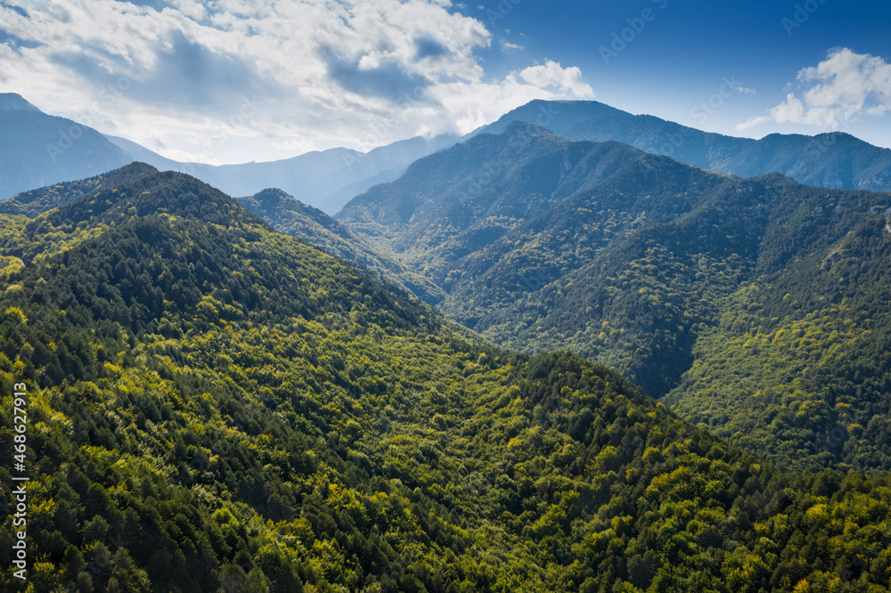 Greece mountains, close to Mount Olympus. Drone landscape. Green forest, blue cloudy sky