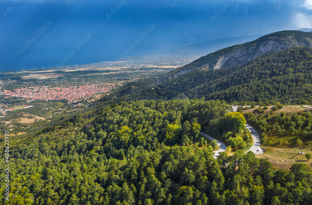Aerial view of mountains, road to Mount Olympus. Green forest, blue sky. Litochoro city on background