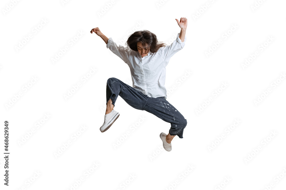 One pretty woman in casual wear jumping, flying isolated on white background. Art, motion, action, flexibility, inspiration concept.