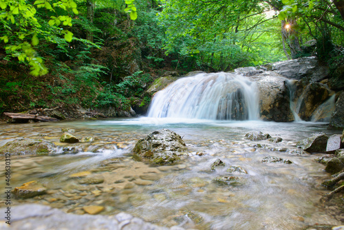 Fototapeta Naklejka Na Ścianę i Meble -  Forest waterfall in a mountainous area on a sunny summer morning
