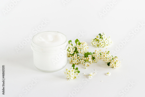 White moisturizing cream cosmetic for spa treatment with blossoms flowers