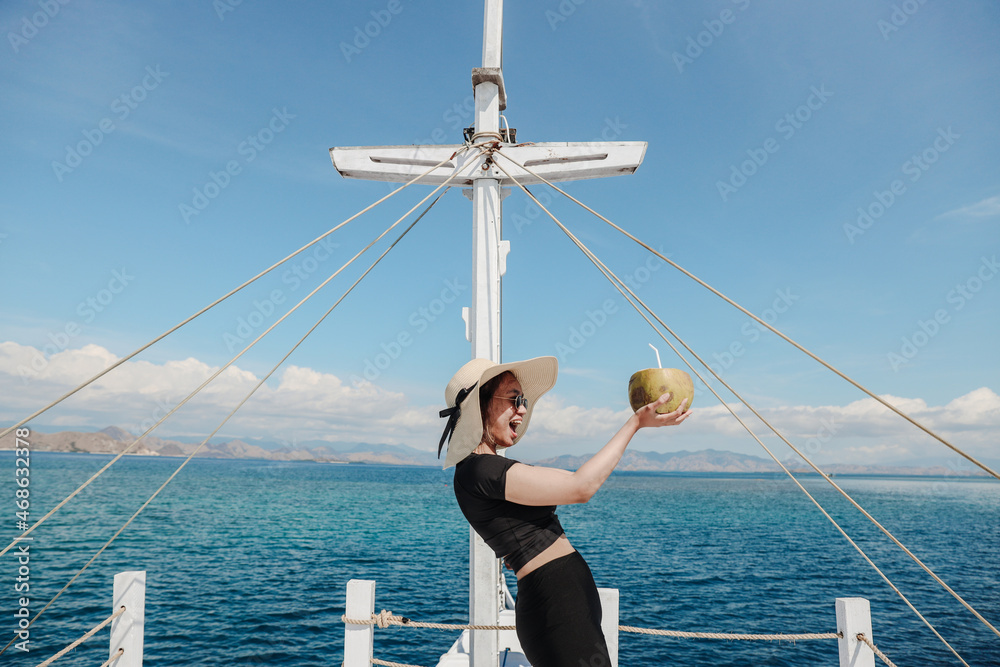 A girl enjoying coconut during summer holiday on the sea A girl enjoying coconut during summer holiday on the sea