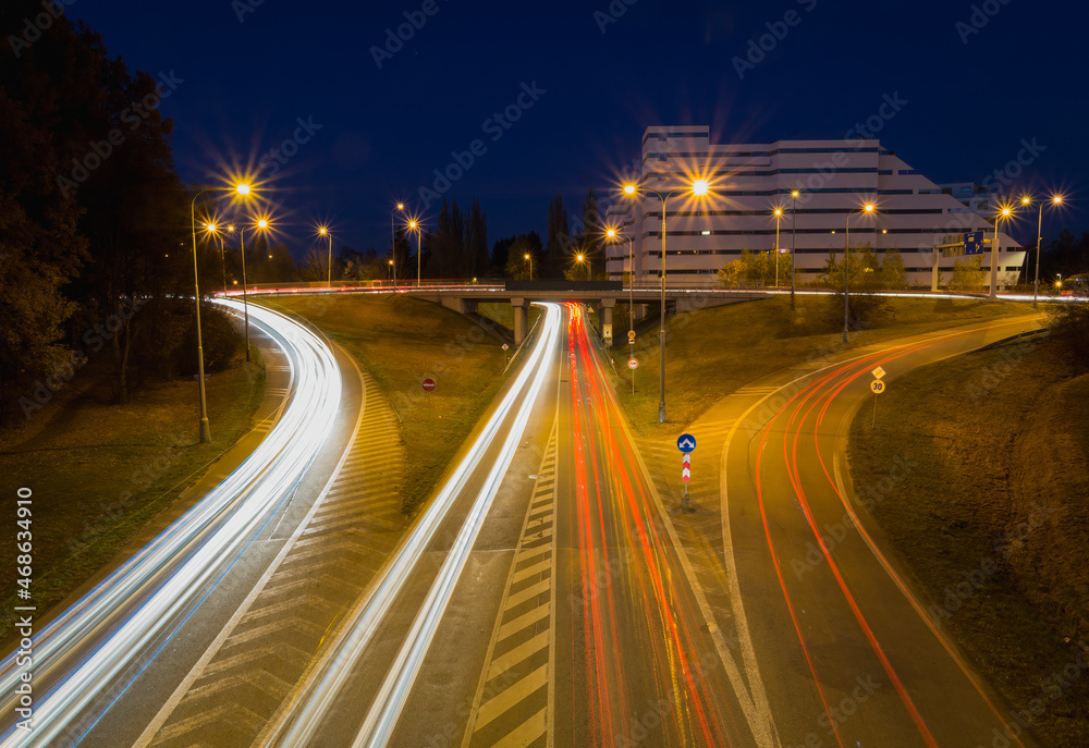 Long exposure car light trail on asphalt road with building and night sky. Traffic concept, Ceske Budejovice, Czech republic