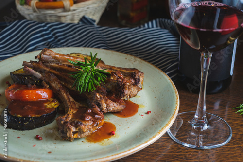 Fried ribs with a glass of red wine on a table in a restaurant close-up