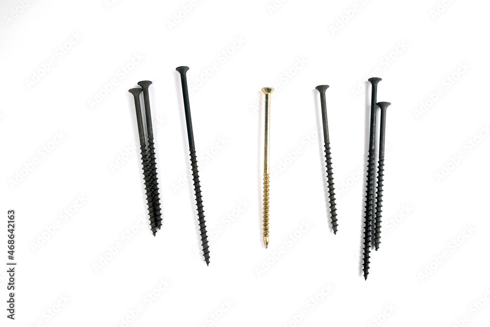 Self-tapping screws on a white background. Gold self-tapping screw and metal screws on a white background. One is different from all. Be different from the crowd. Be a special person Self-tapping screws on a white background. Gold self-tapping screw and metal screws on a white background. One is different from all. Be different from the crowd. Be a special person