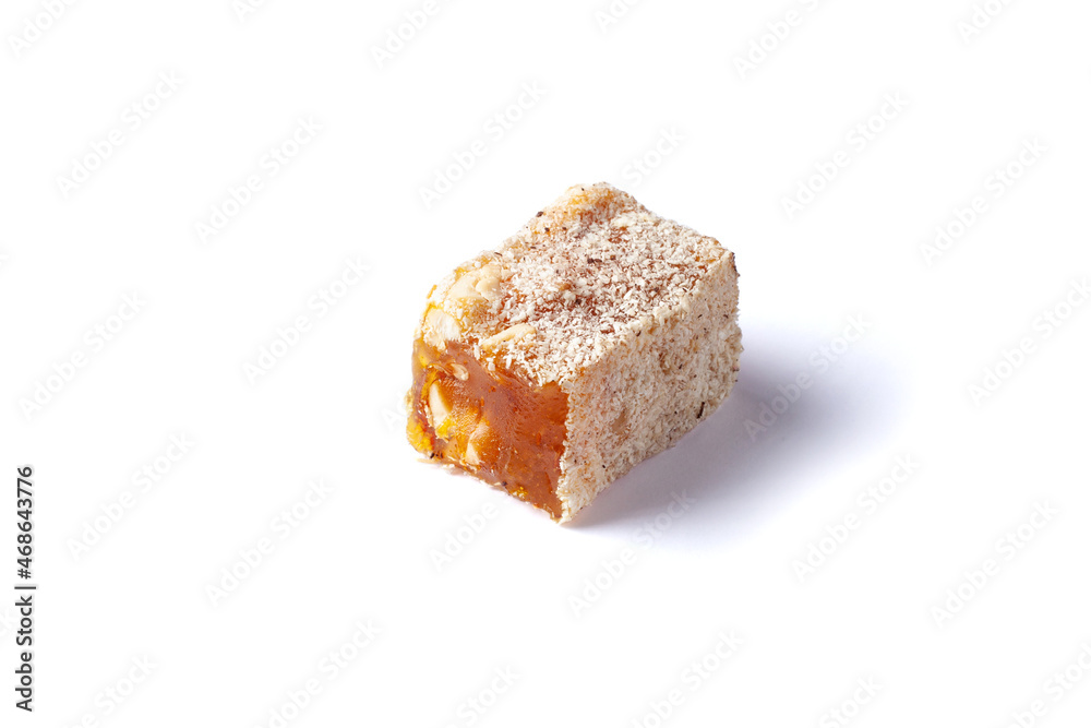 Turkish delight isolated on white background. Lokum covered coconut flakes. Fruit jelly candy with hazelnut. close up