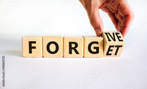 Forgive and forget symbol. Businessman turns a wooden cube and changes the word forgive to forget. Beautiful white background, copy space. Business, psychological forgive and forget concept. photo