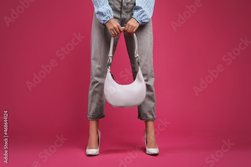 Fashionable woman with stylish bag on pink background, closeup
