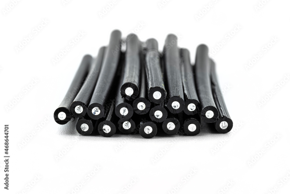 A stack of cut fiber optic cables lying on top of each other, isolated on a white background.