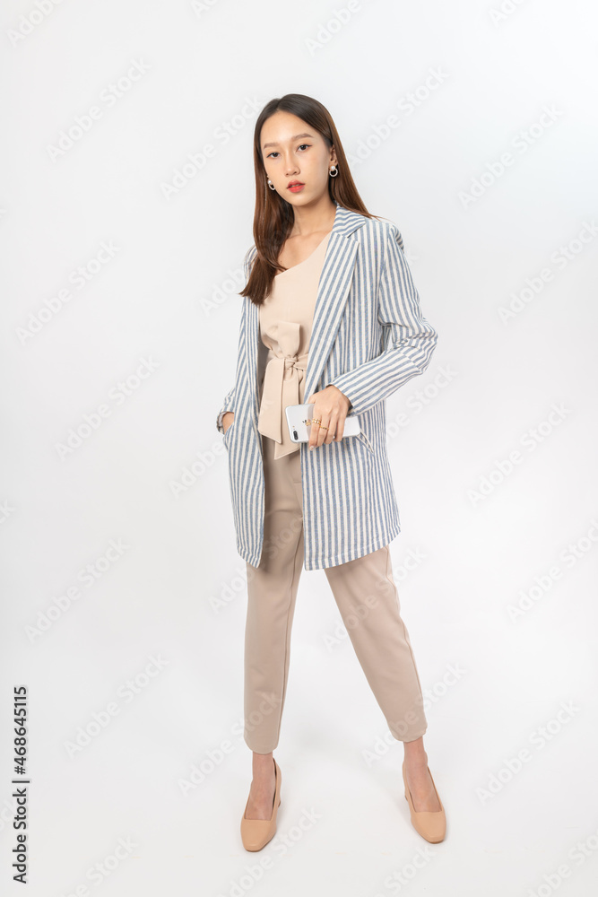 Photograph of a young, beautiful and sexy asian Thai lady model in professional business attire with a mobile phone on hand Photograph of a young, beautiful and sexy asian Thai lady model in professional business attire with a mobile phone on hand