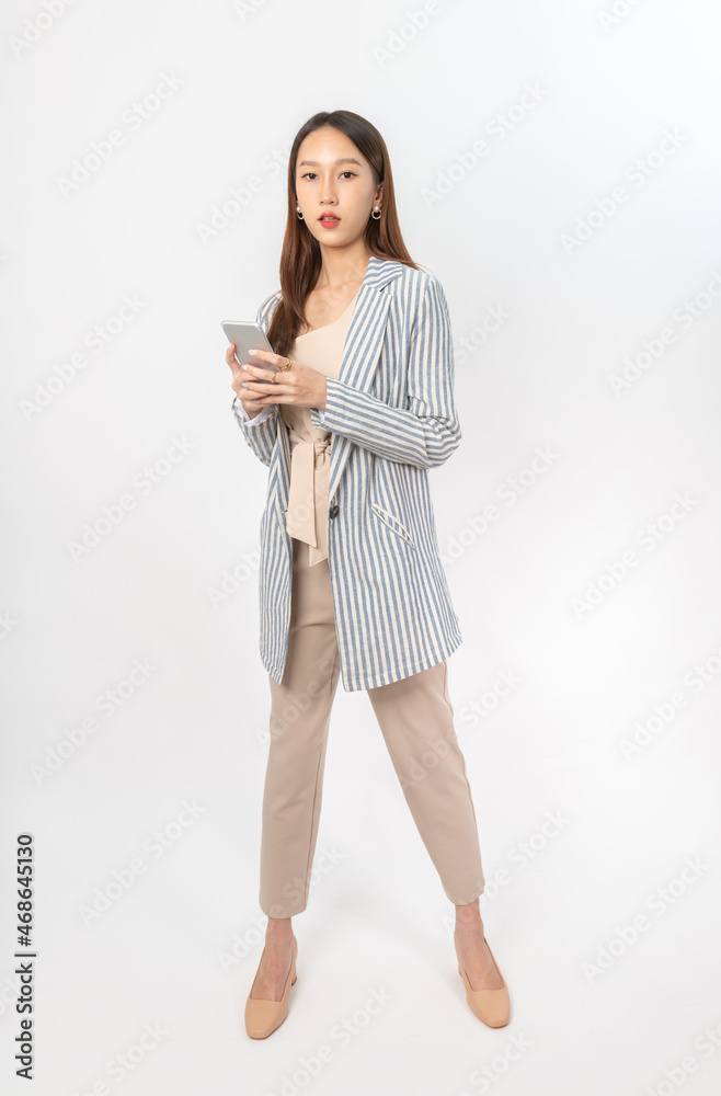 Photograph of a young, beautiful and sexy asian Thai lady model in professional business attire with a mobile phone on hand Photograph of a young, beautiful and sexy asian Thai lady model in professional business attire with a mobile phone on hand