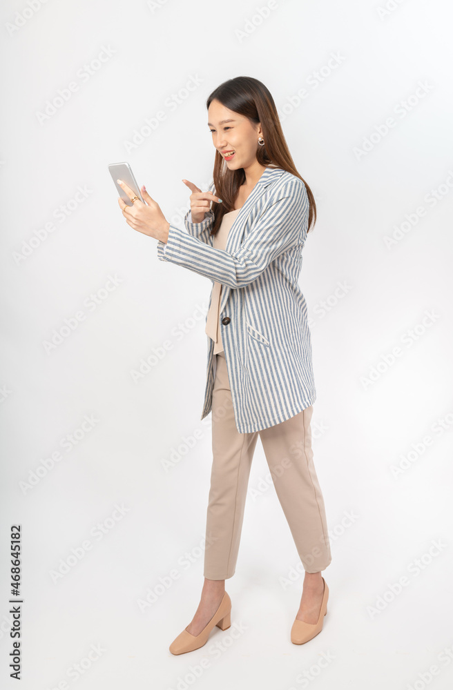 Photograph of a young, beautiful and sexy asian Thai lady model in professional business attire with a mobile phone on hand Photograph of a young, beautiful and sexy asian Thai lady model in professional business attire with a mobile phone on hand