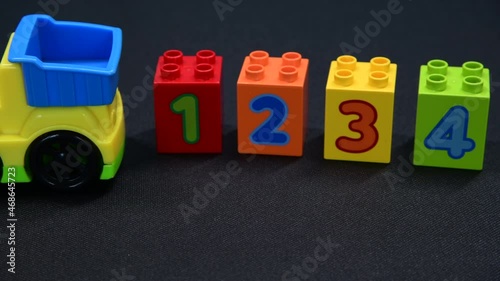 Children’s toy truck and building blocks of varying colours and numbers one to four are also visable. photo