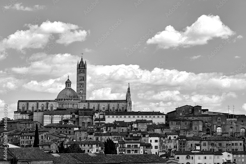 Historic houses and bell tower and dome of the medieval cathedral in Siena