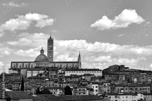 Historic houses and bell tower and dome of the medieval cathedral in Siena