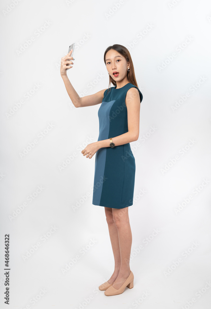 Photograph of a young, beautiful and sexy asian Thai lady model in professional business attire with a mobile phone on hand Photograph of a young, beautiful and sexy asian Thai lady model in professional business attire with a mobile phone on hand