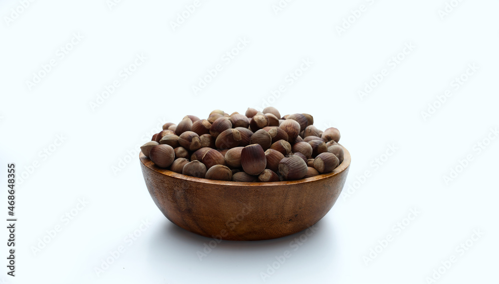 nuts in a wooden plate on a white background nuts in a wooden plate on a white background